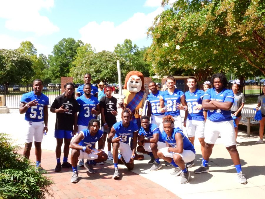 The Blue Hose football team pose with PC mascot Scotty the Scotsman.