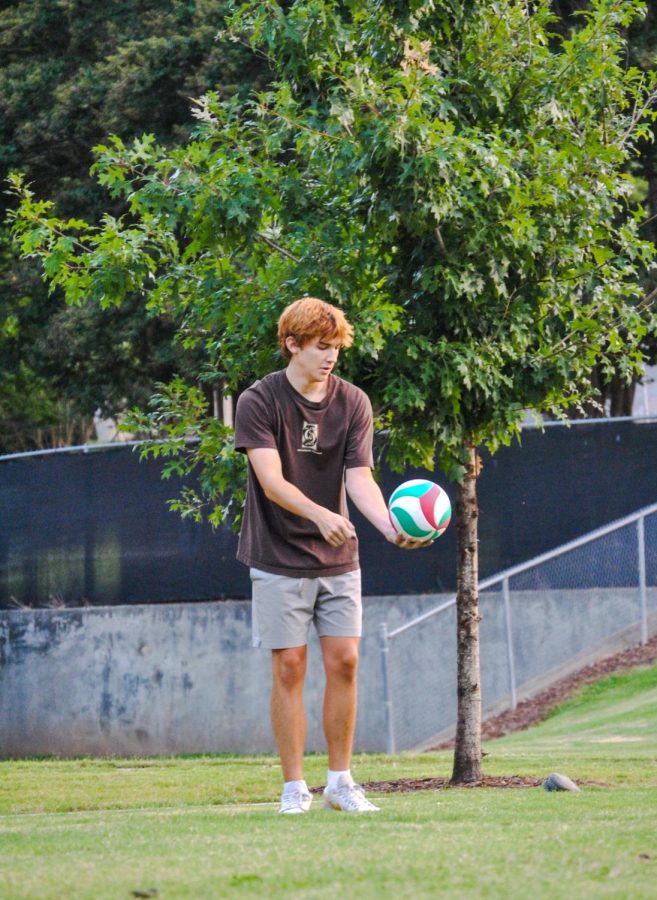 A player begins to serve the volleyball.