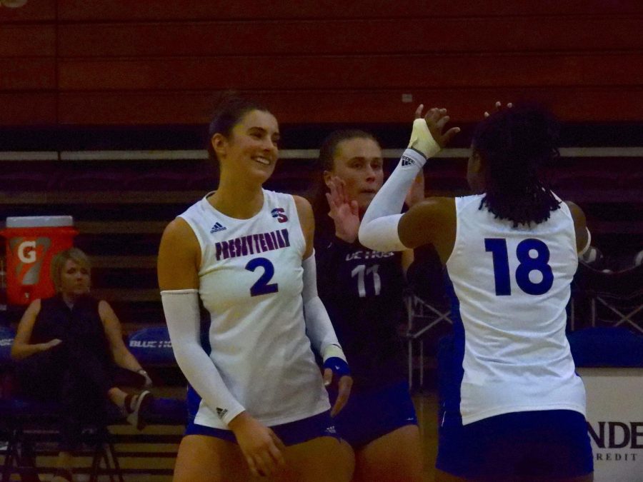 Middle blocker Elyse Hutchinson celebrates with Hewitt and outside hitter Kasey Battle.
