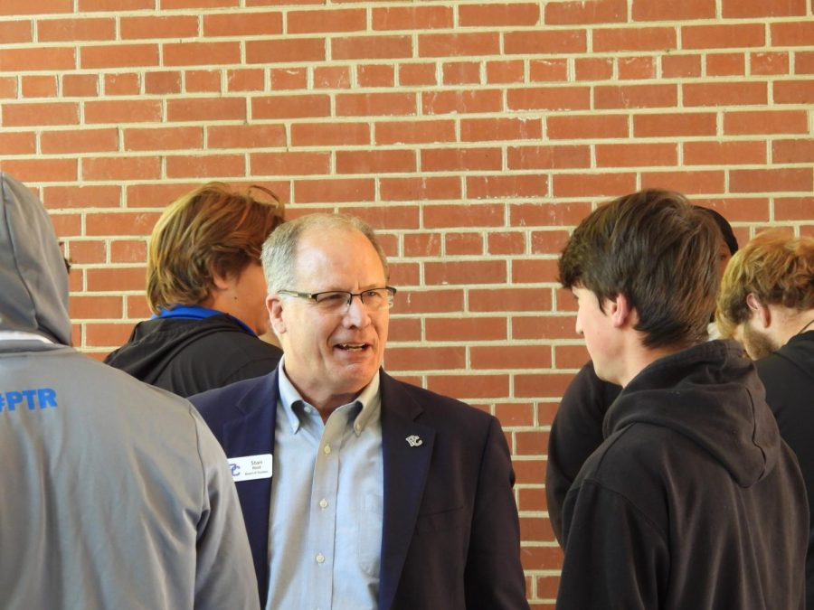 PC Board of Trustees member Stan Reid (74) chats with a student outside Belk Auditorium.