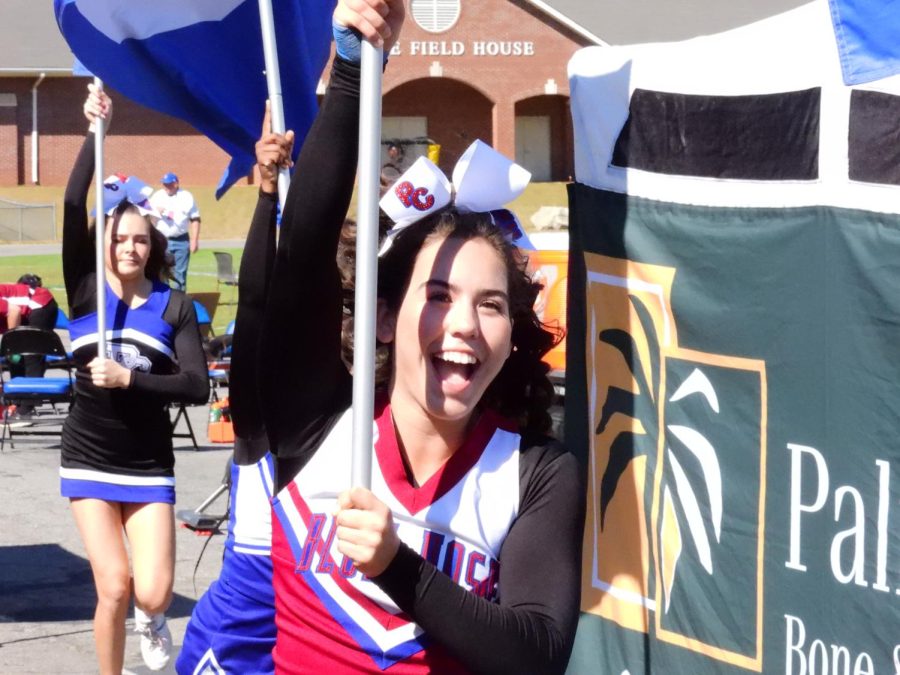 A Blue Hose cheerleader runs in excitement after a PC touchdown.