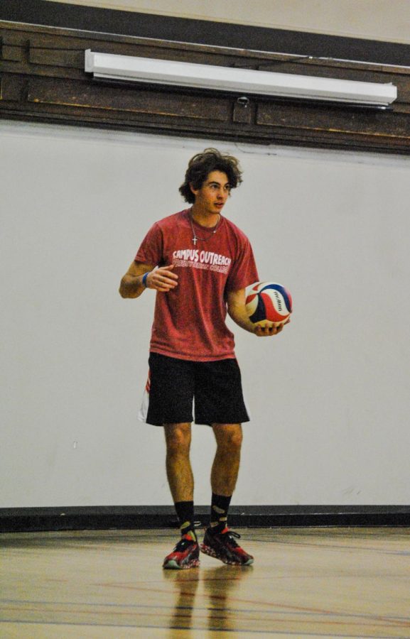 Gabe Butler getting ready to toss the ball up to serve.
